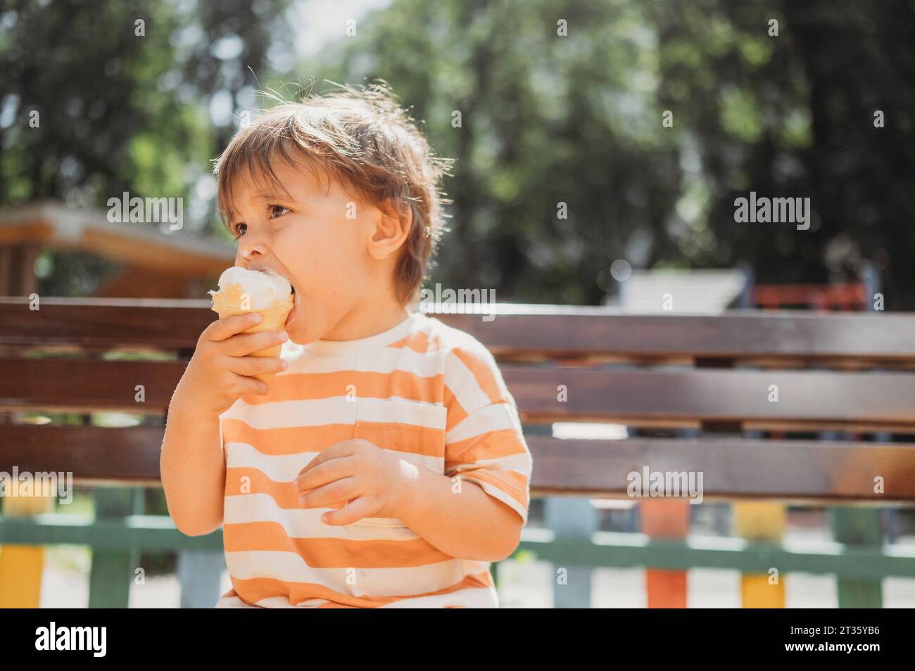 Nachdenklicher Junge, der Eis im Park trinkt Stockfoto