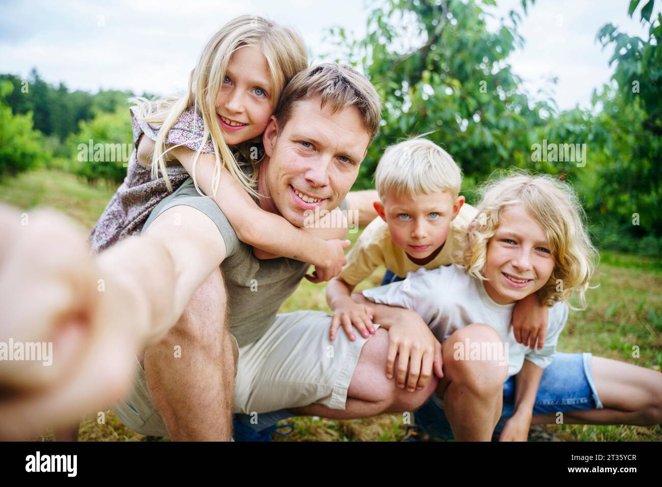 Vater mit Kindern, die Selfie im Garten machen Stockfoto