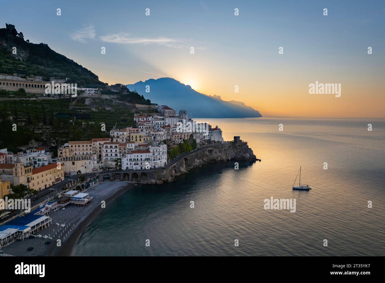 Das Meer mit dem Schiff in der Nähe der Stadt bei Sonnenaufgang Stockfoto
