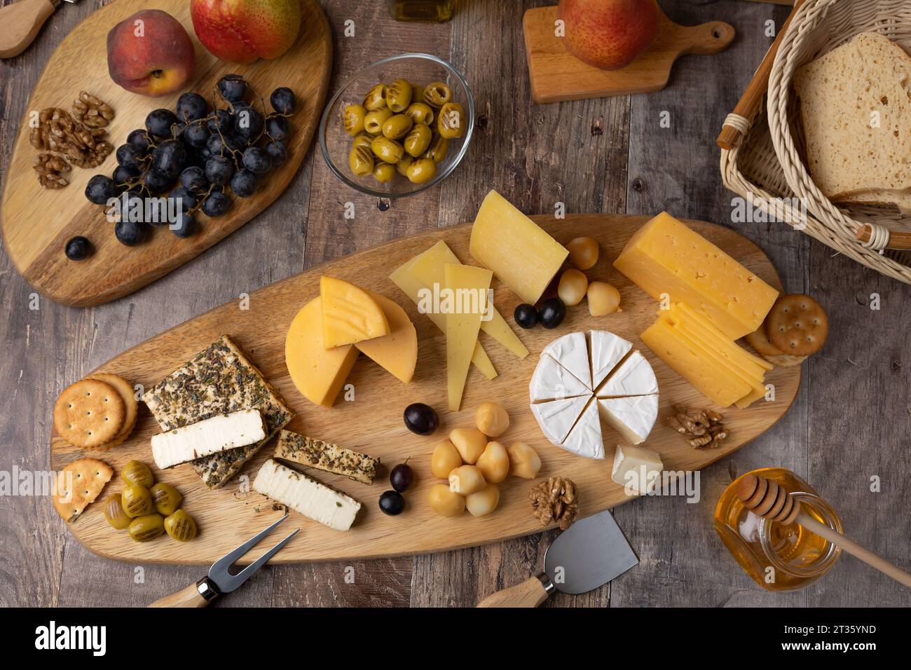 Käse auf Holzbrett, rustikaler Stil. Mehrere in Scheiben geschnittene ...
