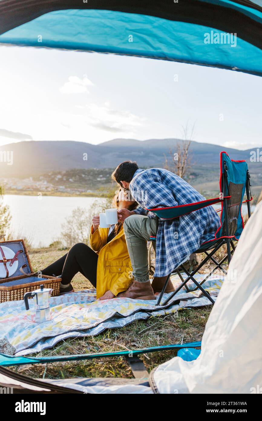 Paare, die sich vor dem Zelt küssen Stockfoto