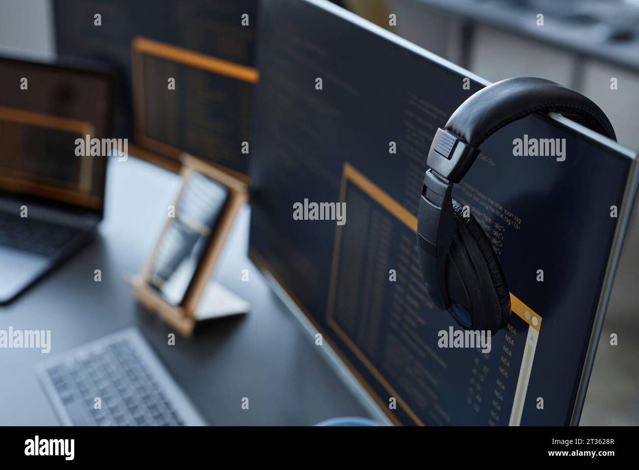 Desktop-PC mit kabellosen Kopfhörern am Schreibtisch Stockfoto
