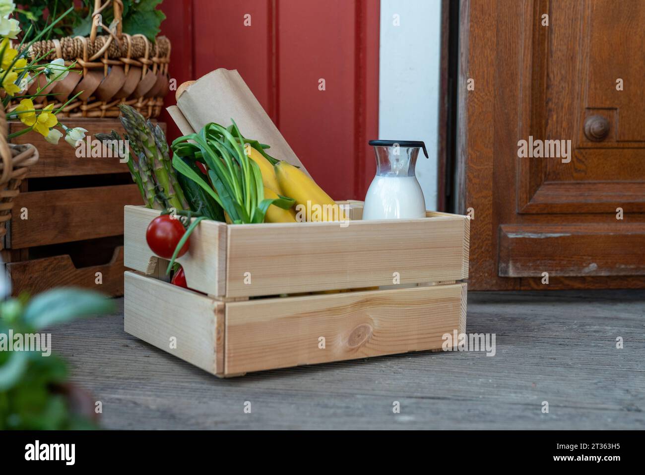 Kiste mit Bio-Lebensmitteln in der Nähe der Haustür Stockfoto