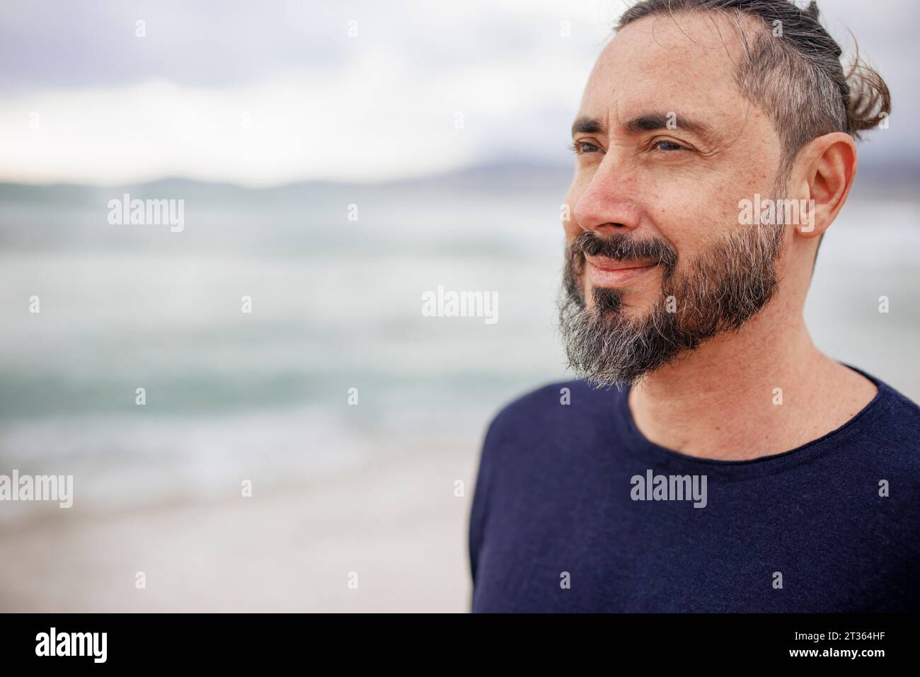 Besinnlicher Mann mit Bart am Strand Stockfoto