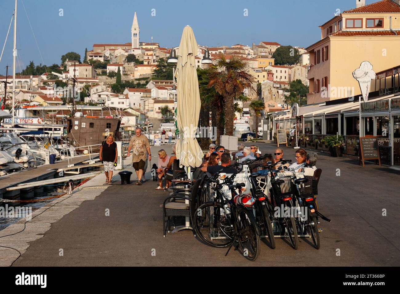 Touristen sitzen in den Coffeeshops an der Yachthafenpromenade, in der Hintergrundstadt Vrsar, Istrien, Kroatien, Europa. Stockfoto