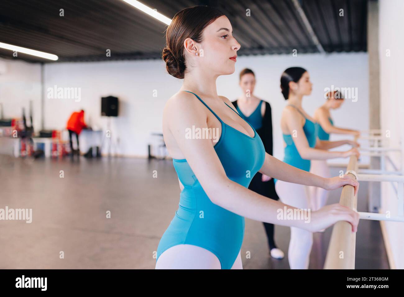 Balletttänzerin hält Geländer in der Tanzschule Stockfoto