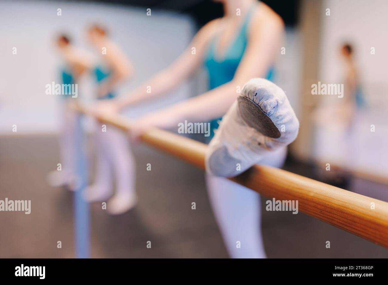 Tänzerin in Ballettschuhen beim Stretching in der Tanzschule Stockfoto