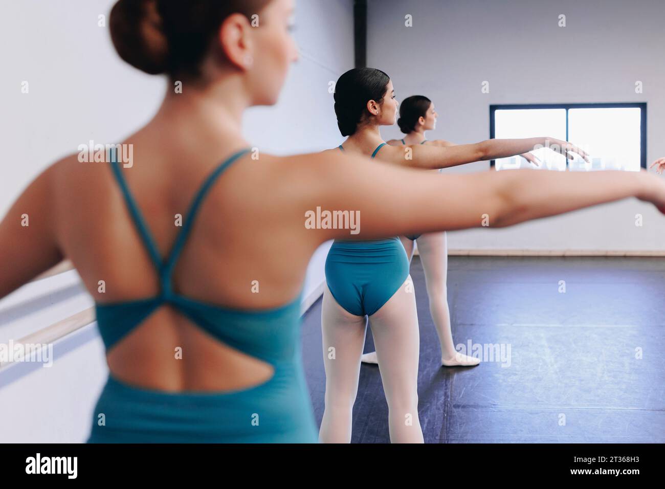 Tänzer üben Ballett mit ausgestreckten Armen in der Tanzschule Stockfoto