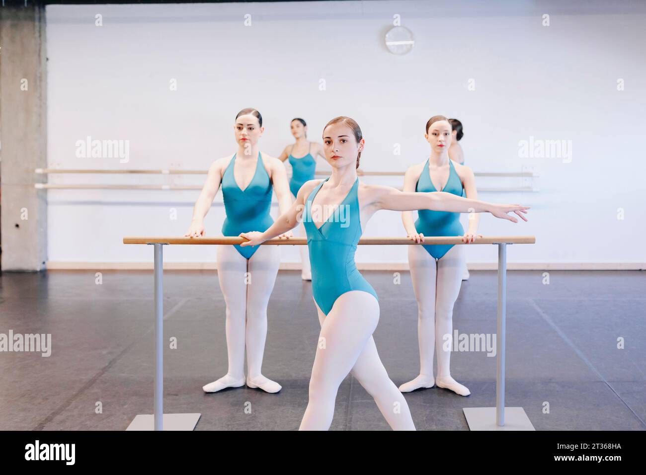 Schüler üben Ballett in der Nähe von Geländern in der Tanzschule Stockfoto