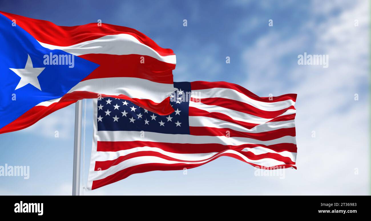 Die Flagge von Puerto Rico, die an klaren Tagen mit der Flagge der Vereinigten Staaten winkt. Puerto Rico ist eine karibische Insel und ein nicht eingetragenes Gebiet der Vereinigten St. Stockfoto