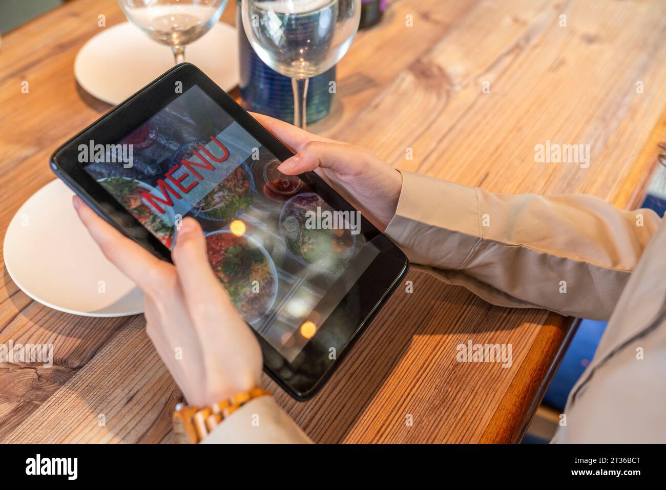 Frau, die im Café Lebensmittel mit einem Tablet-PC bestellt Stockfoto