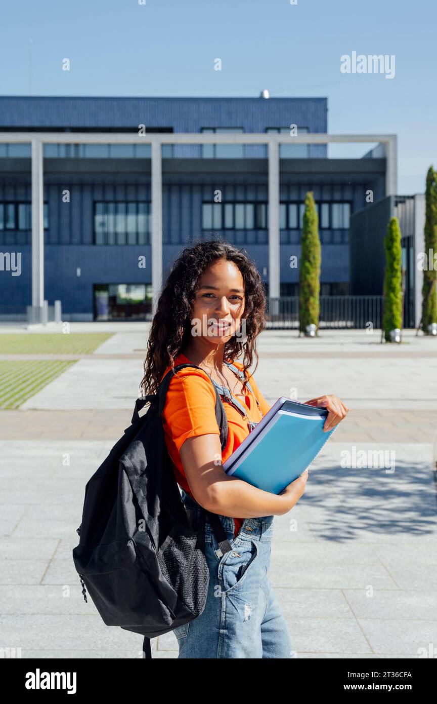 Junge Studentin mit Rucksack auf dem Campus Stockfoto