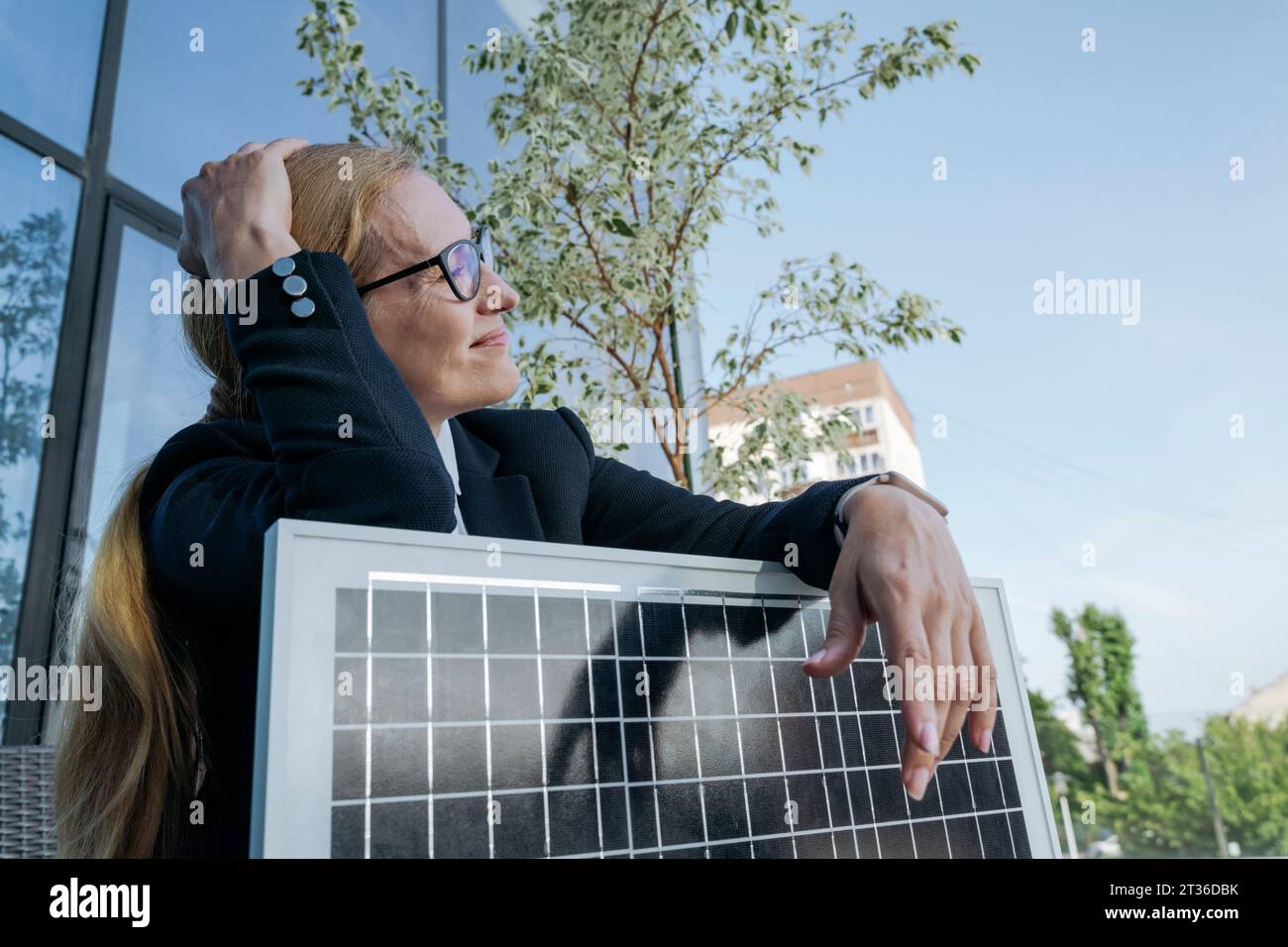 Besinnliche Geschäftsfrau mit Sonnenkollektor im Business Center Stockfoto