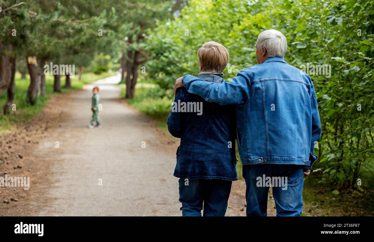 Liebevolle ältere Ehepaare, die zusammen im Wald spazieren Stockfoto