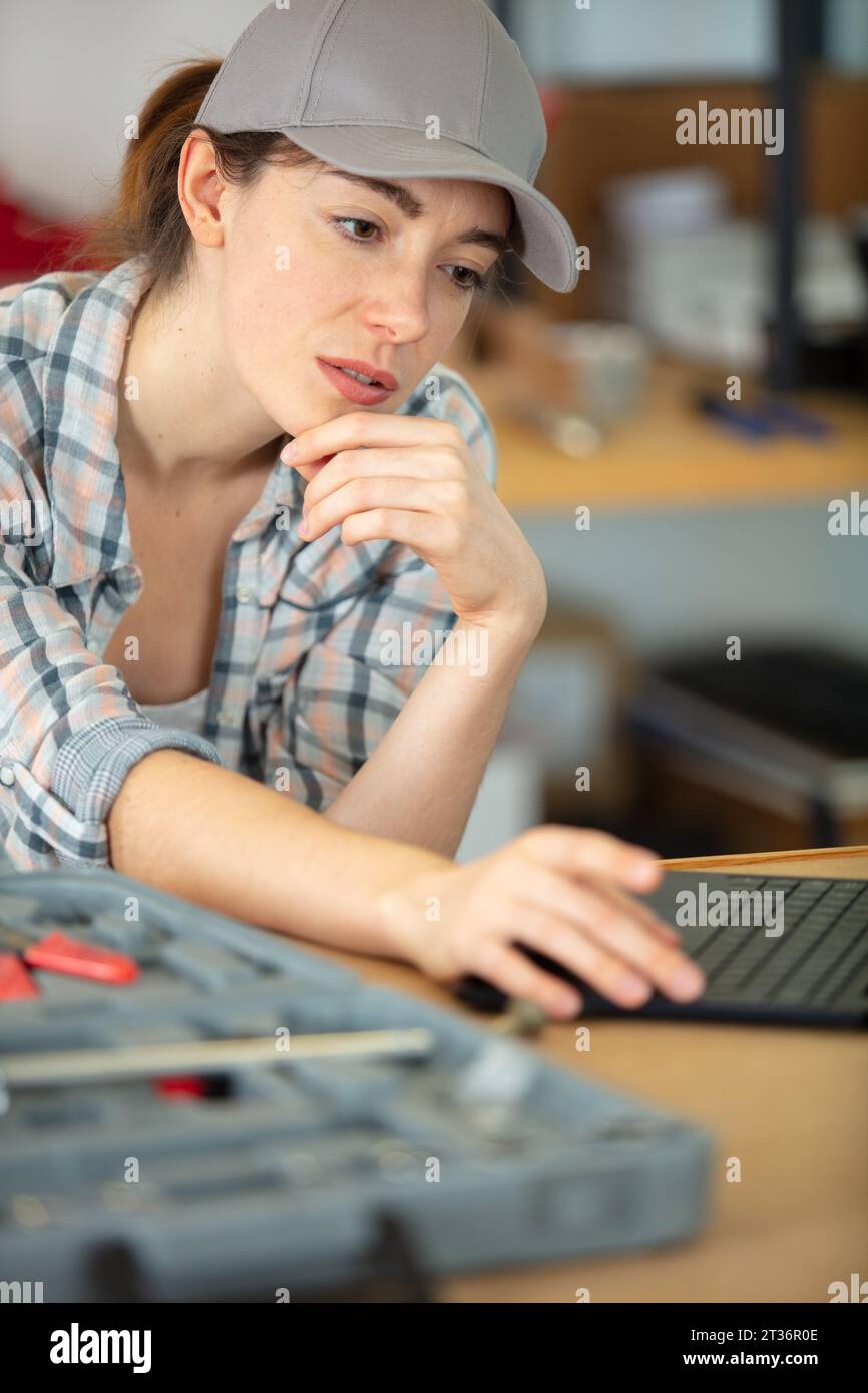 Weibliche Ingenieurin mit Laptop in einer Werkstatt Stockfoto