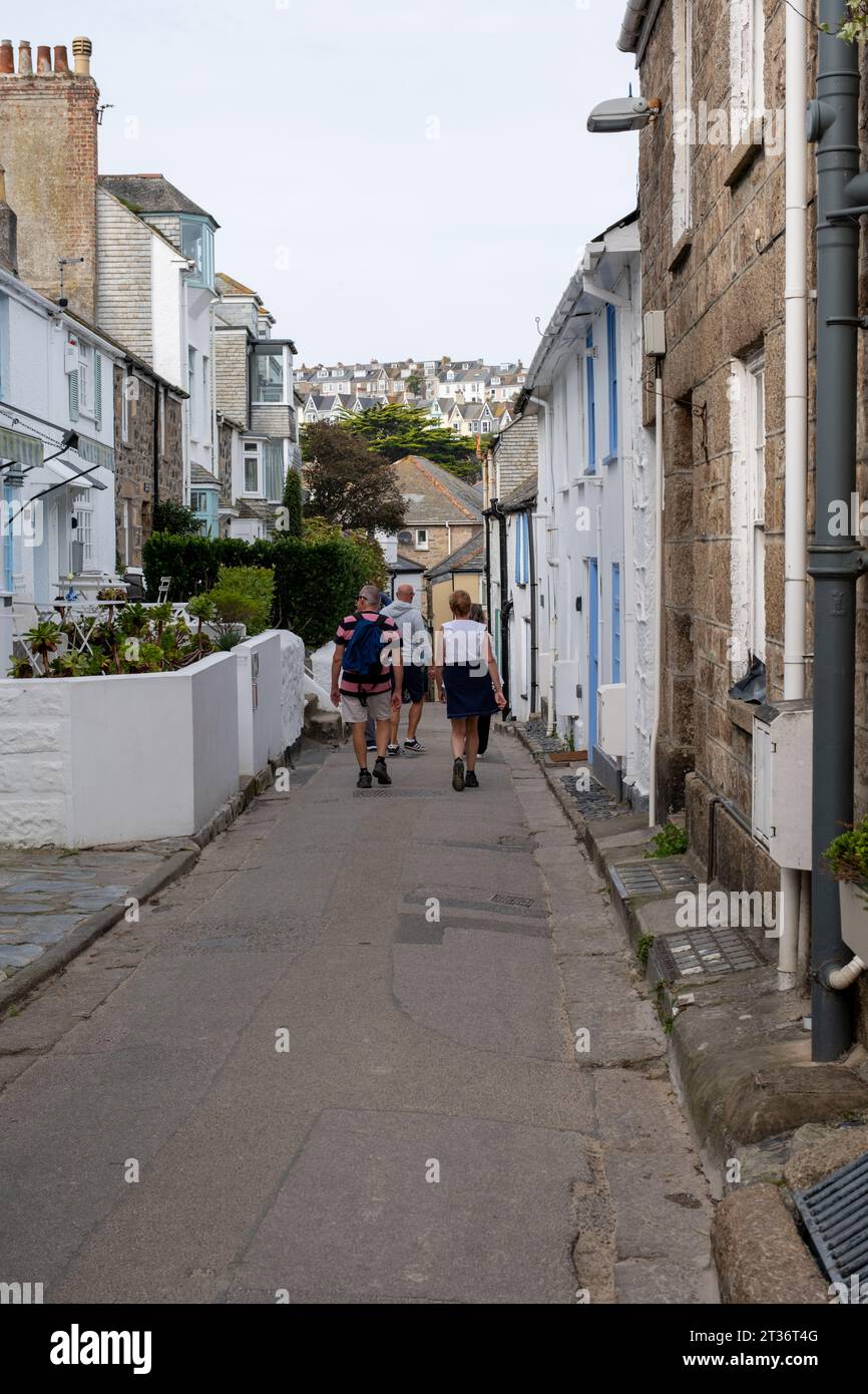 Urlauber, die die schmale Straße in St Ives, Cornwall, Großbritannien, entlang laufen Stockfoto