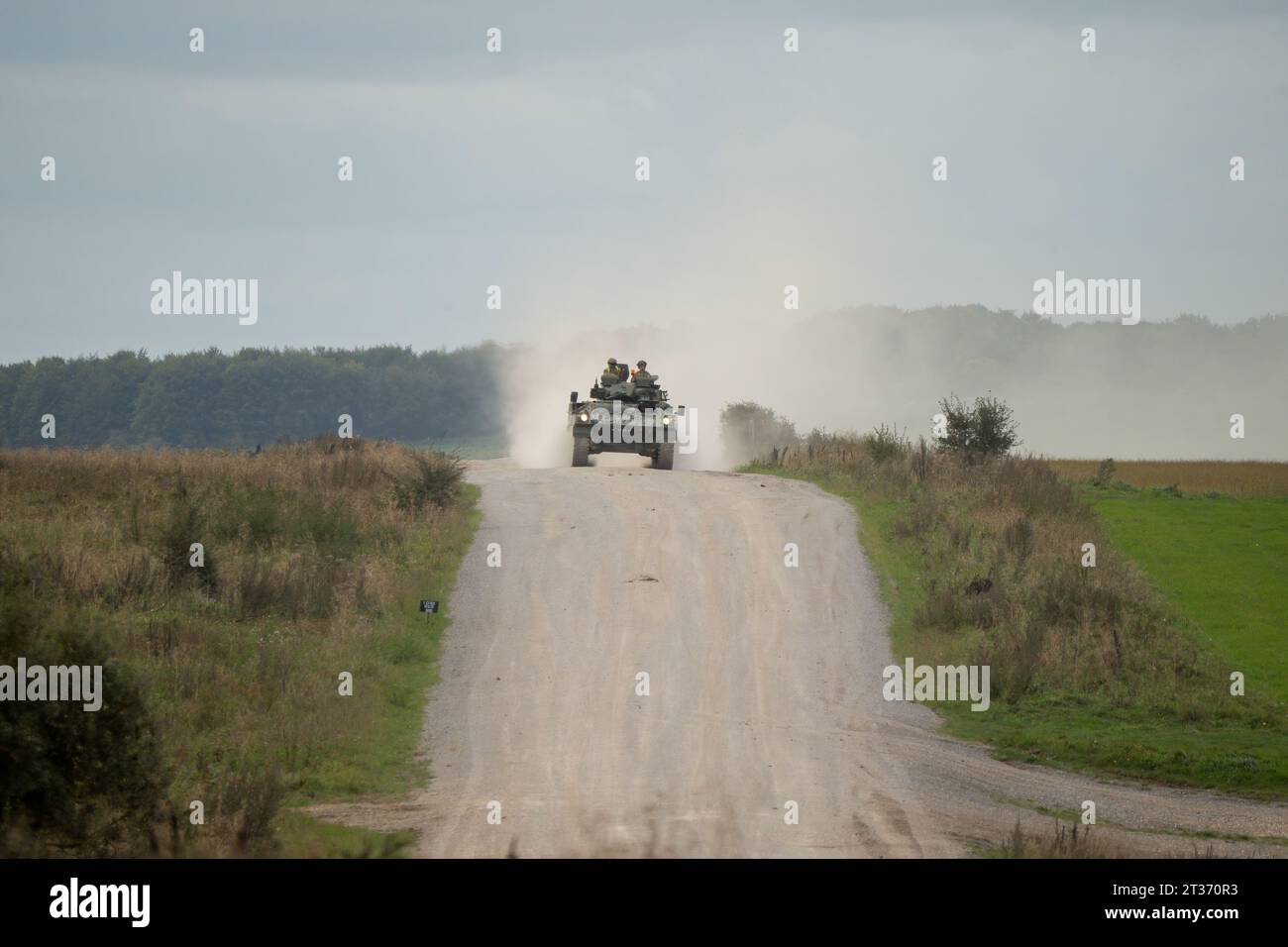 Das Kampffahrzeug der britischen Armee FV510 Warrior Infantry wirft Wolken aus Staub auf, während es auf einem Feldweg fährt Stockfoto