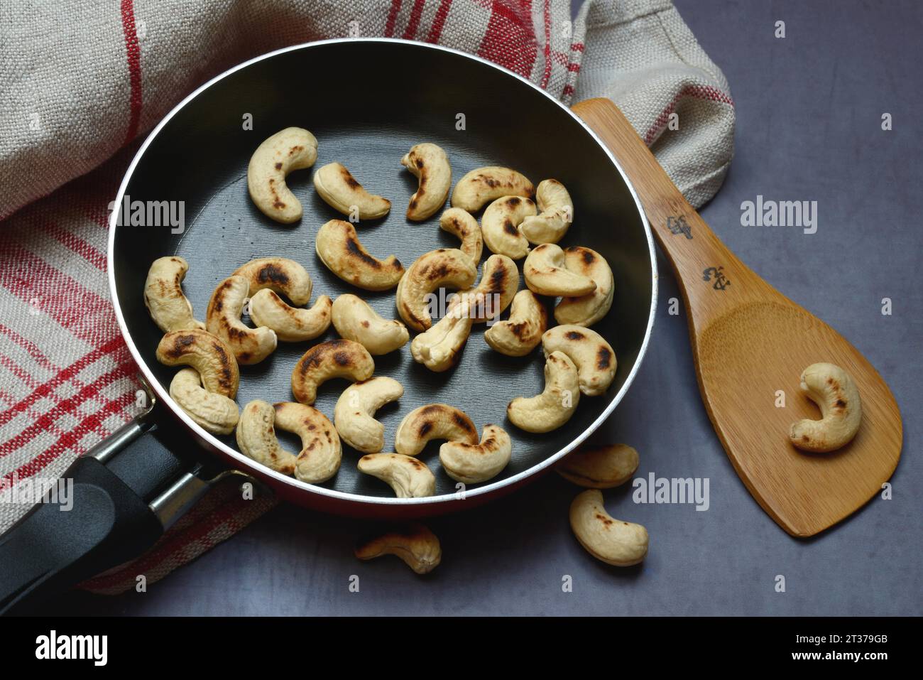 Cashew, geröstete Cashewkerne in der Pfanne mit Kelle Stockfoto