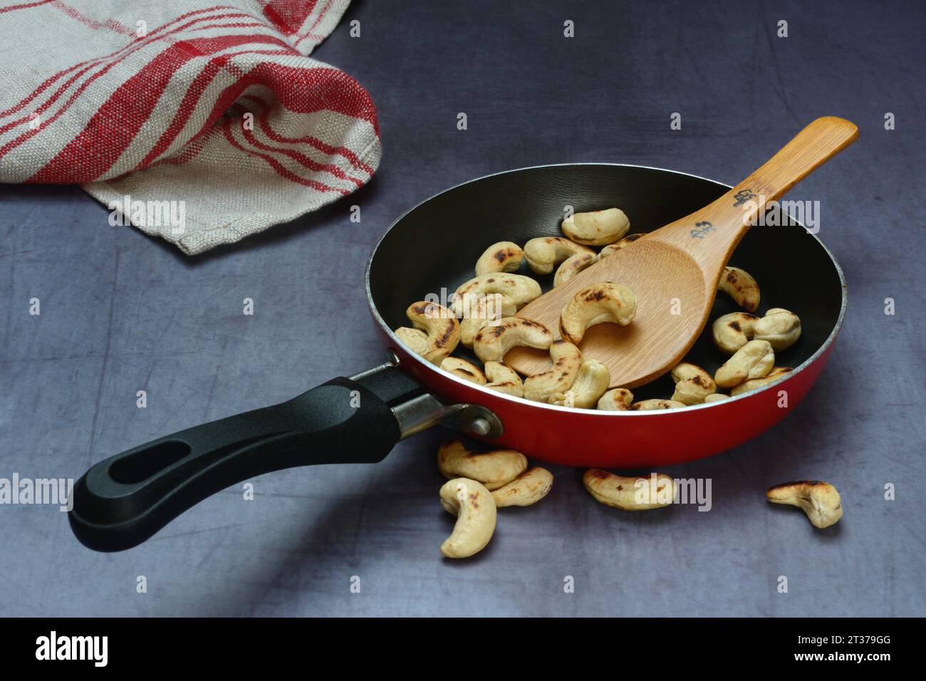 Cashew, geröstete Cashewkerne in der Pfanne mit Kelle Stockfoto
