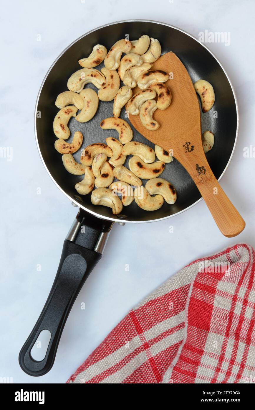 Cashew, geröstete Cashewkerne in der Pfanne mit Kelle Stockfoto