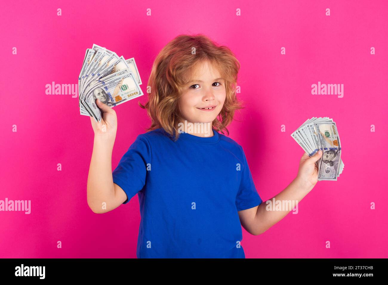Der Junge hat eine Menge von hundert Dollar isoliert auf Studiohintergrund. Spendensparendes Wohltätigkeits- und Finanzierungskonzept Stockfoto