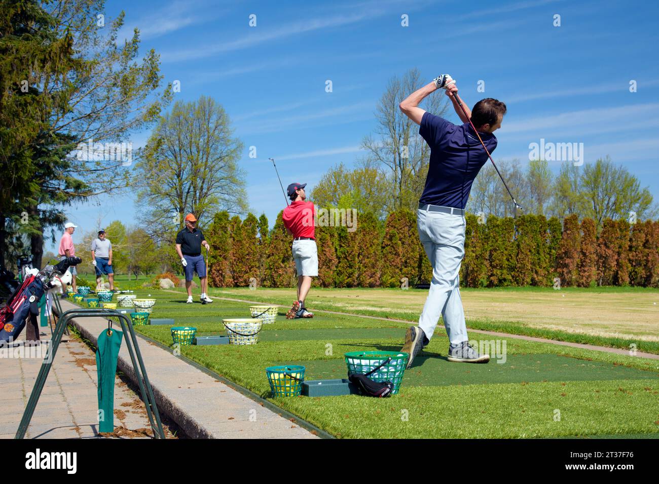 Golfspieler üben ihren Schwung auf einer Driving Range Stockfoto