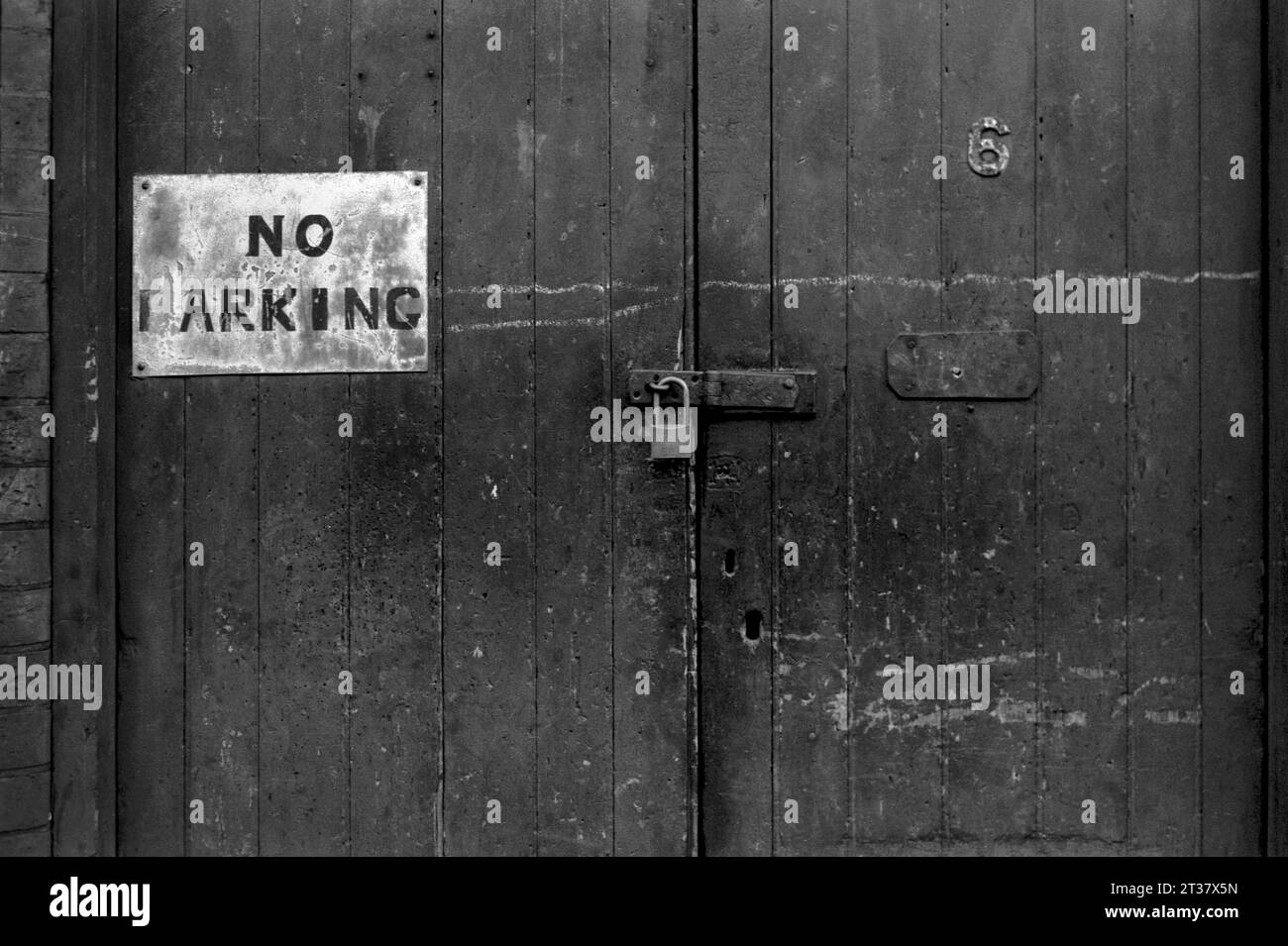 Mit einem Vorhängeschloss verriegelte Holztüren zu einem Hof auf der Rückseite des Grundstücks, fotografiert während der Räumung des Slums und des Abbruchs von St. Ann's, Nottingham. 1969-72 Stockfoto