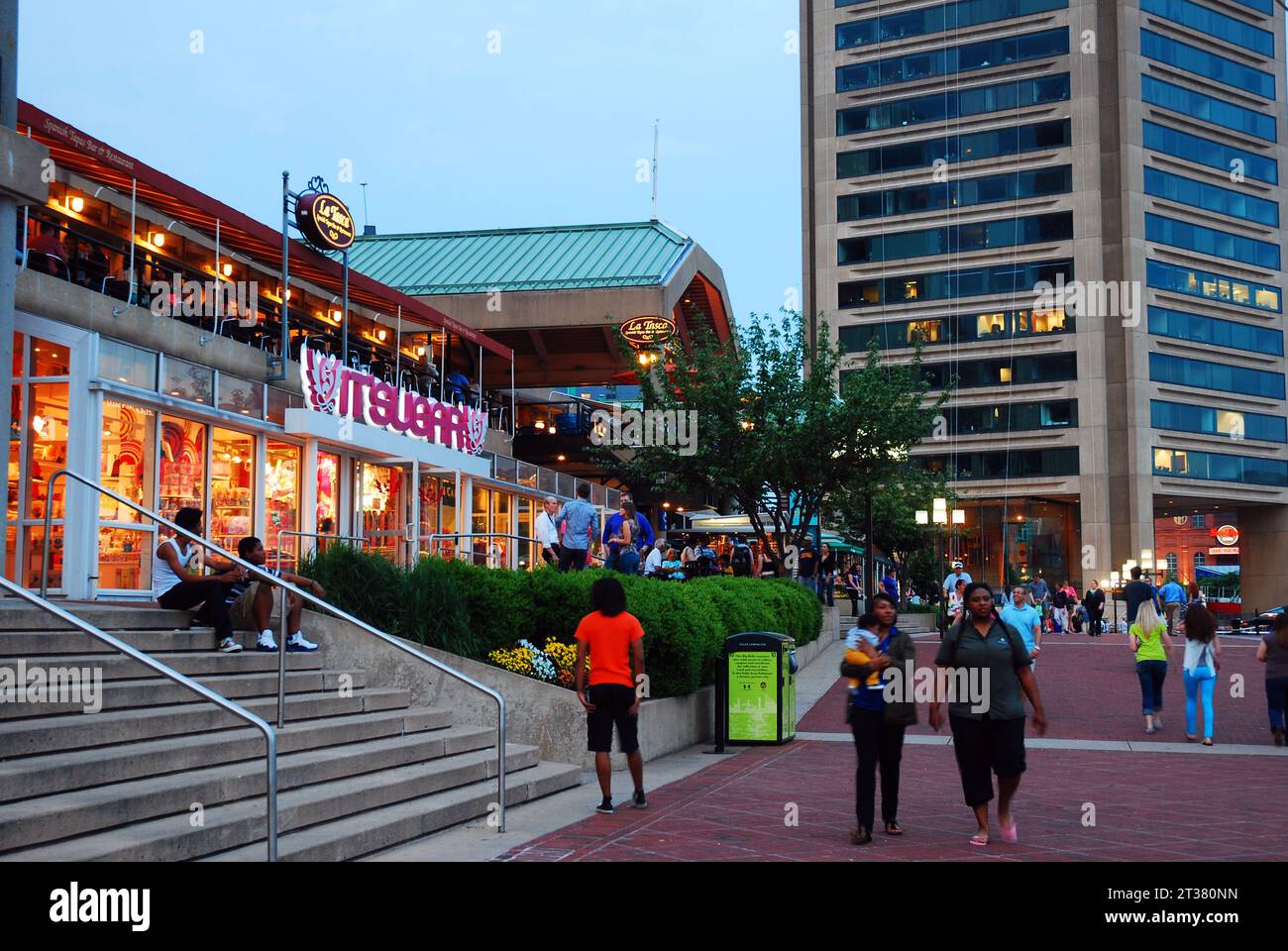 Die Menschen genießen eine warme Sommernacht bei einem Spaziergang durch die Einzelhandelsgeschäfte und Geschäfte im Inner Harbor Viertel von Baltimore Stockfoto