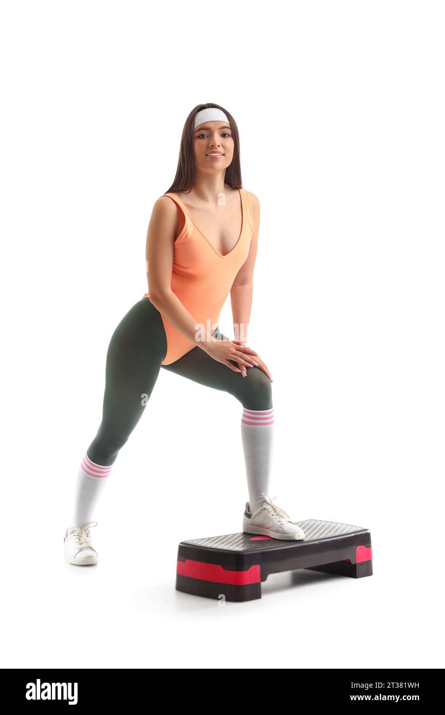 Sportliche junge Frau mit Stepper, die Aerobic auf weißem Hintergrund macht Stockfoto