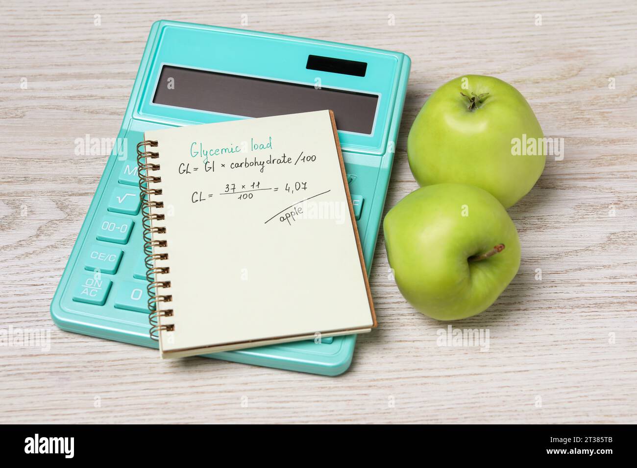 Notizbuch mit berechneter glykämischer Belastung für Äpfel, Taschenrechner und frisches Obst auf hellem Holztisch Stockfoto