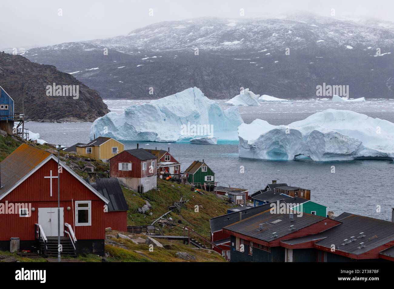 Farbenfrohe Häuser und Eisberge in Kullorsuaq, Grönland Stockfoto