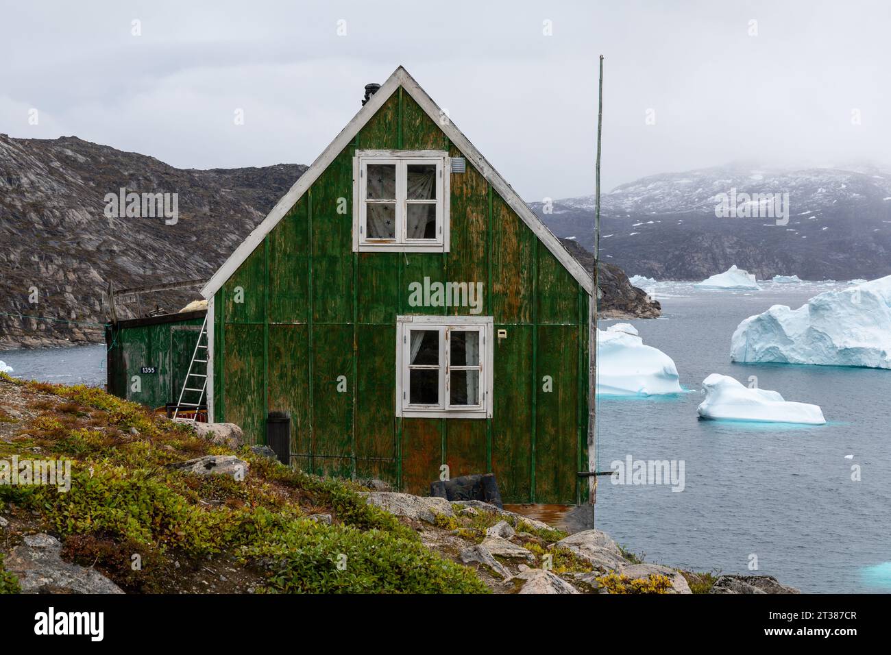 Farbenfrohe Häuser und Eisberge in Kullorsuaq, Grönland Stockfoto