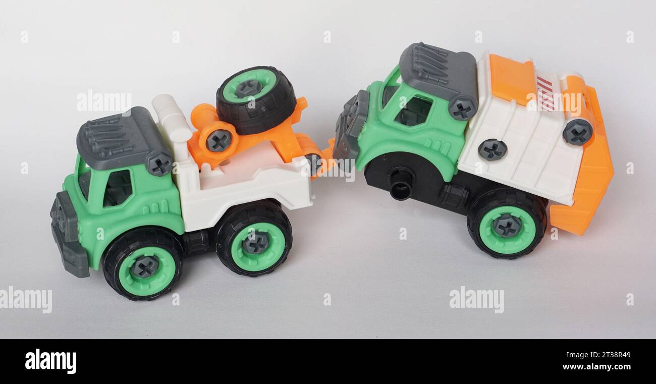 DIY-Kunststoff-Truck-Spielzeug isoliert auf weiß. Schwerlastfahrzeug schleppt beschädigten Müllwagen ab. Das selbstgebaute Spielzeug steigert die Kreativität der Kinder. Stockfoto
