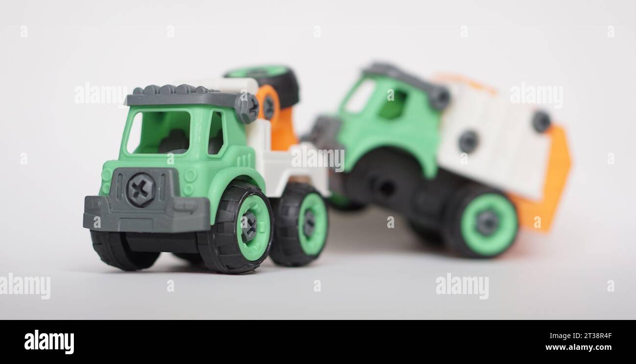 DIY-Kunststoff-Truck-Spielzeug isoliert auf weiß. Schwerlastfahrzeug schleppt beschädigten Müllwagen ab. Das selbstgebaute Spielzeug steigert die Kreativität der Kinder. Stockfoto