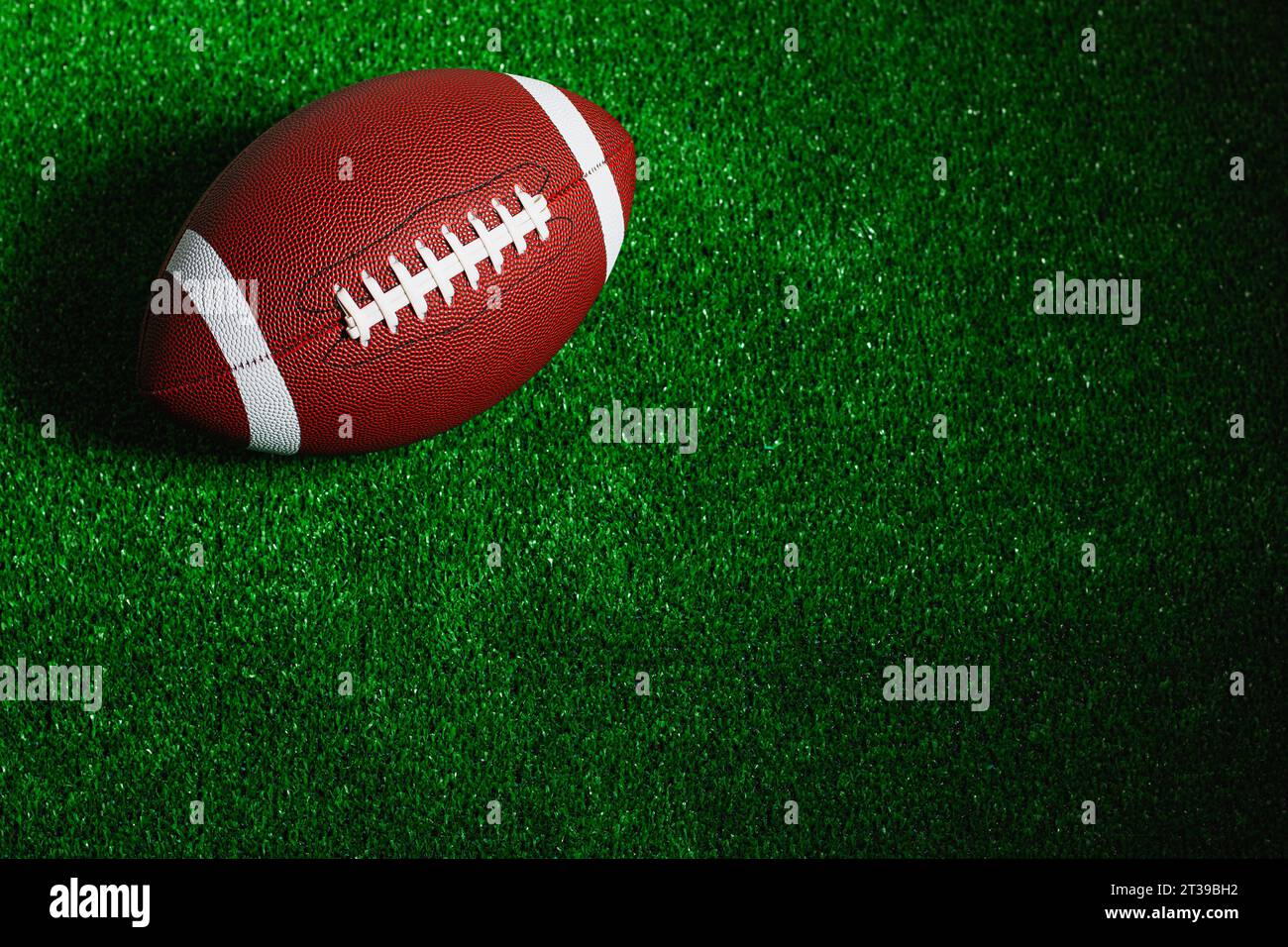 Ein american Football Ball isoliert auf grünem Gras von oben gesehen. Stockfoto