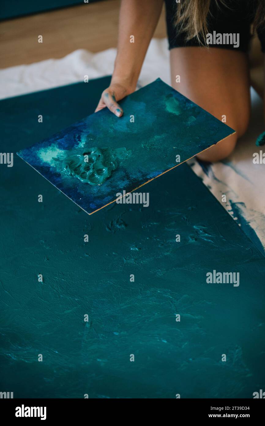 Nicht wiedererkennbare gesichtslose Künstlermalerei auf Palette mit Ölfarbe im Atelier Stockfoto