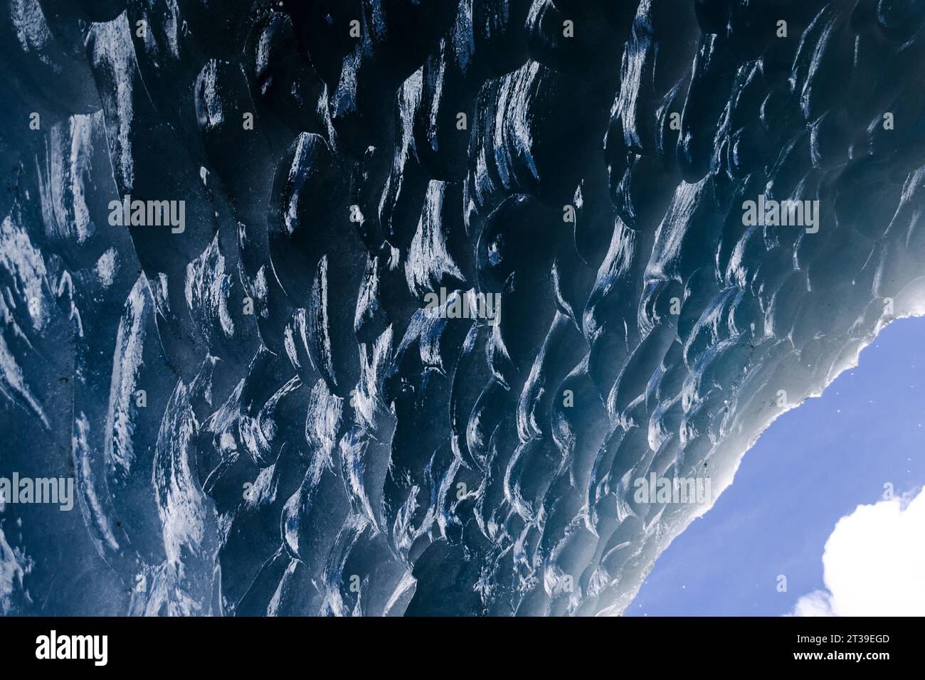 Nahaufnahme der komplexen Eisformationen an einer Höhlendecke mit einem Hauch von Himmel in der Ecke. Stockfoto
