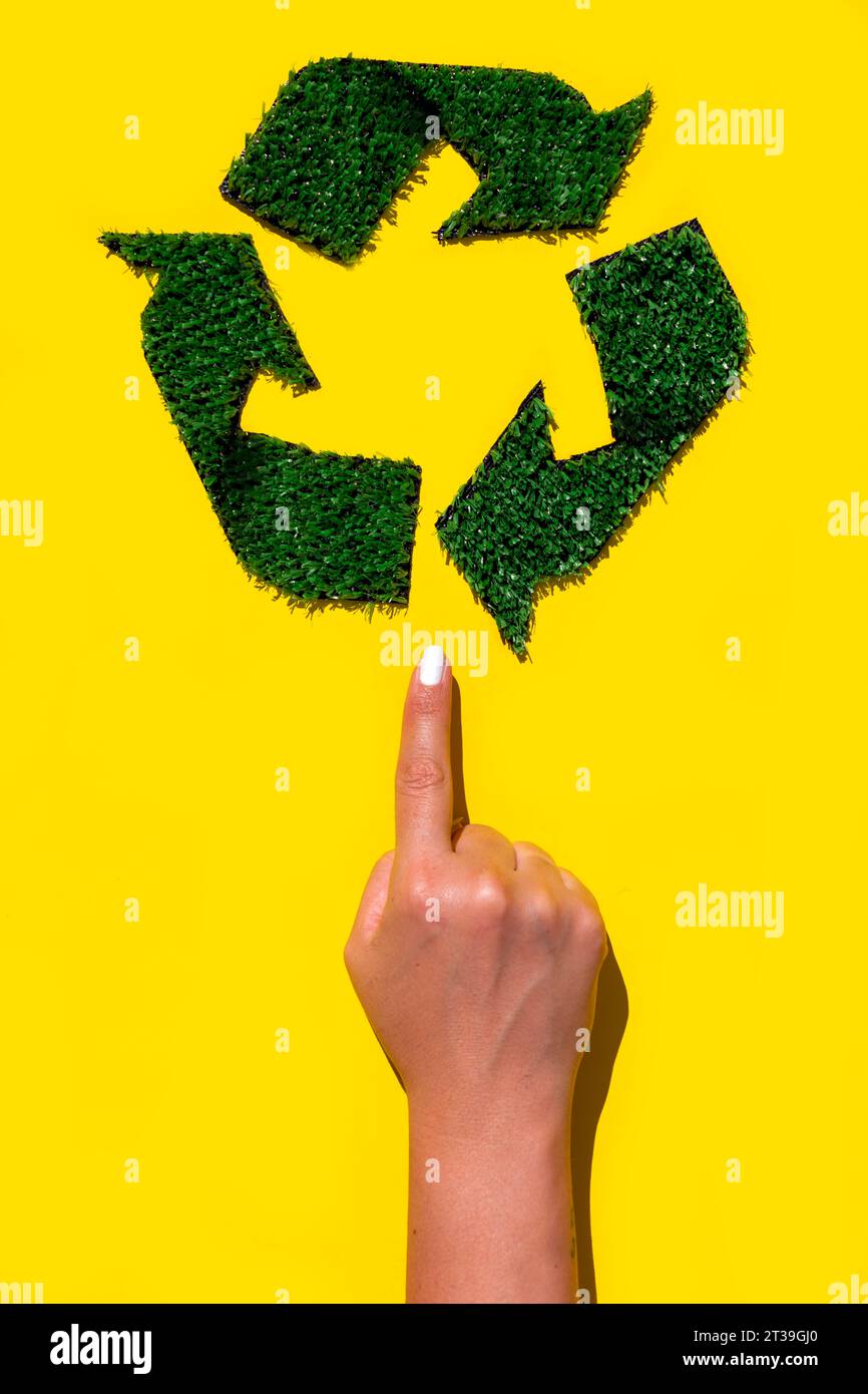 Foto nachhaltiger Praktiken mit einer Hand, die auf ein grünes Recycling-Symbol zeigt Stockfoto