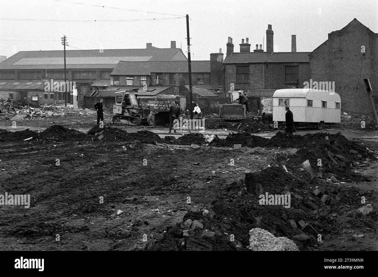 Contracters und Polizisten transportieren Reisende und ihre Karawanen aus dem Brachland während der Slumräumung von St. Ann's, Nottingham. 1969-1972 Stockfoto