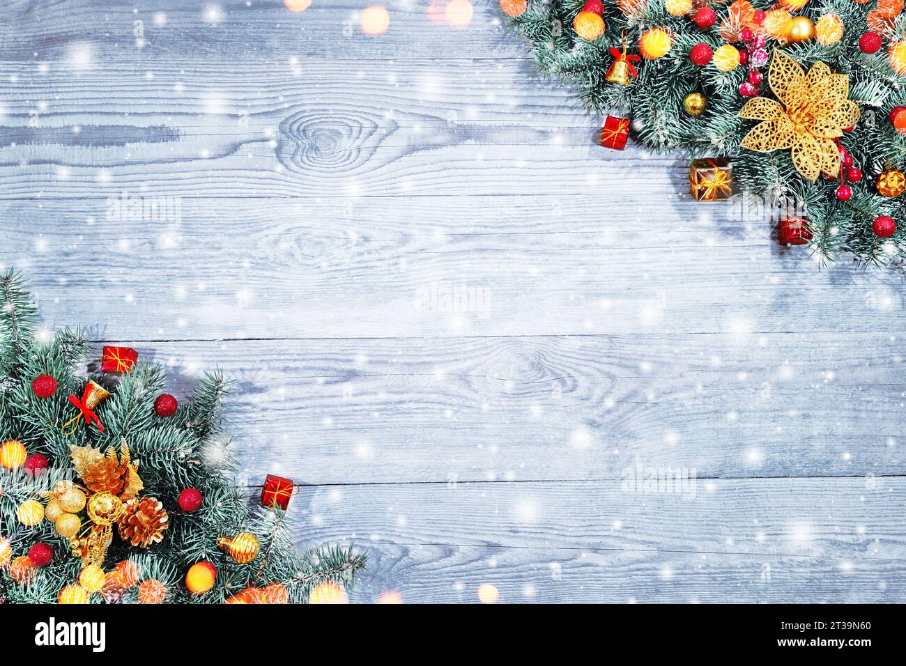 Tannenzweige mit Spielzeug auf altem Holztisch mit Bokeh-Licht. Schöne Weihnachten Hintergrund. Stockfoto