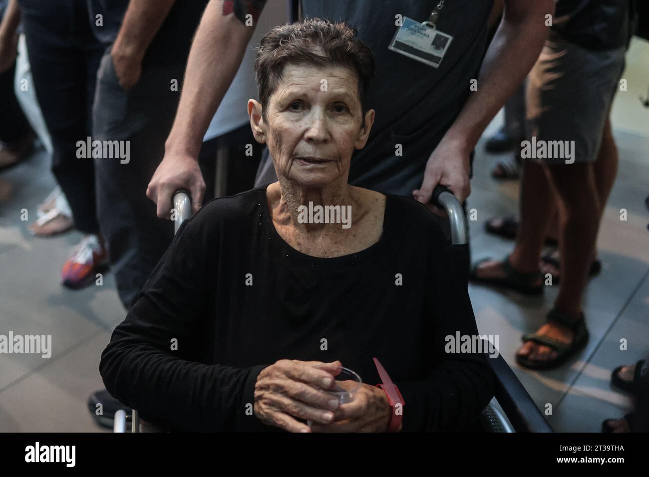 Tel Aviv, Israel. Oktober 2023. Yocheved Lifshitz, eine der beiden freigelassenen Geiseln, hält eine Tasse Wasser, während sie das Ichilov Krankenhaus verlässt, nachdem sie letzte Nacht von der Hamas aus dem Gazastreifen entlassen wurde. Quelle: Ilia Yefimovich/dpa/Alamy Live News Stockfoto