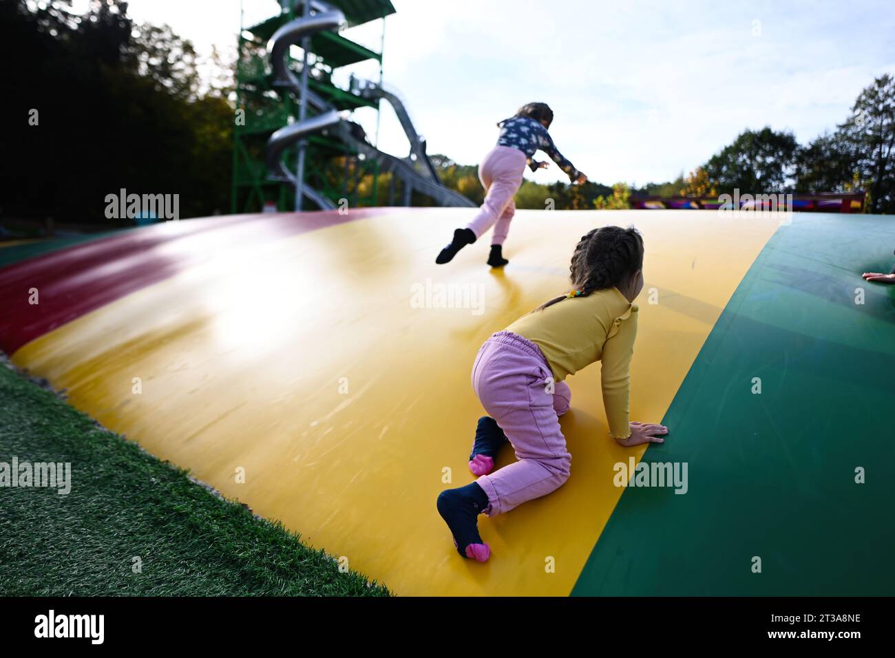 Zwei kleine Mädchen, die Spaß auf einem Trampolin im Park haben. Stockfoto