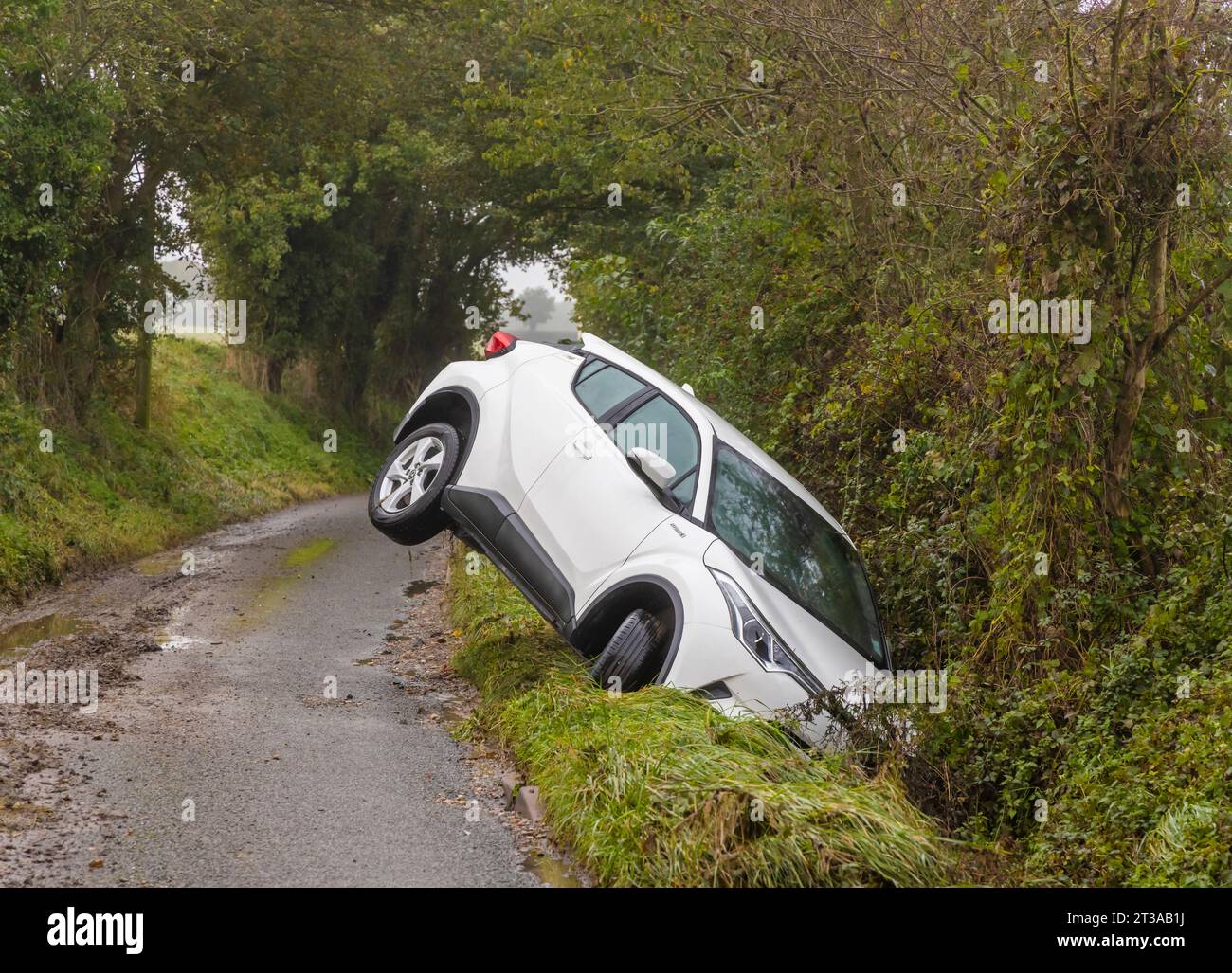 Verlassenes weißes Auto in einem Graben auf einer Landstraße nach Storm Babet. UK Stockfoto