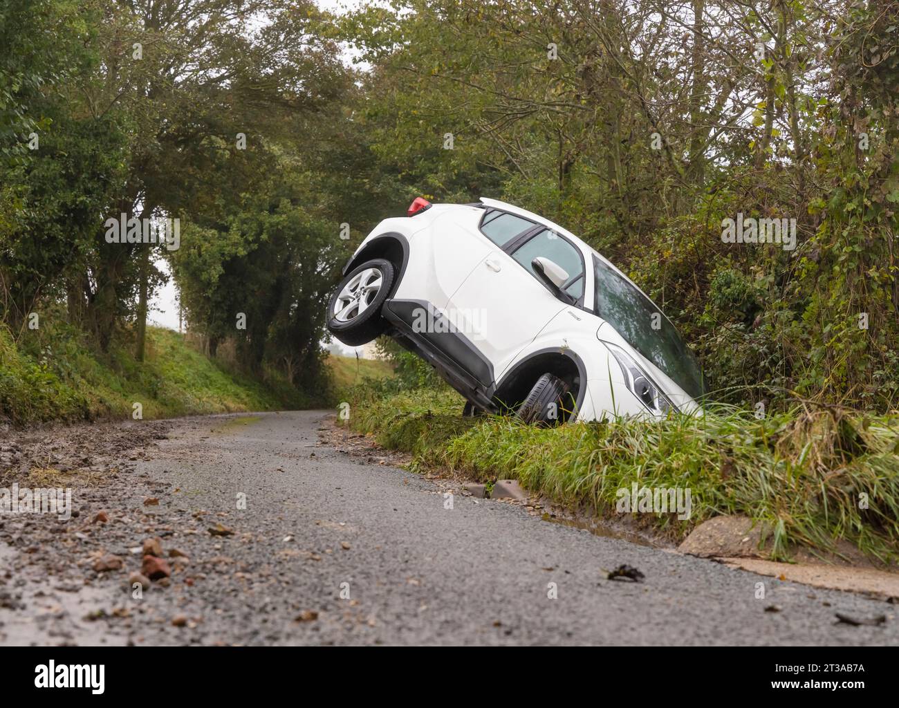 Verlassenes weißes Auto in einem Graben auf einer Landstraße nach Storm Babet. UK Stockfoto