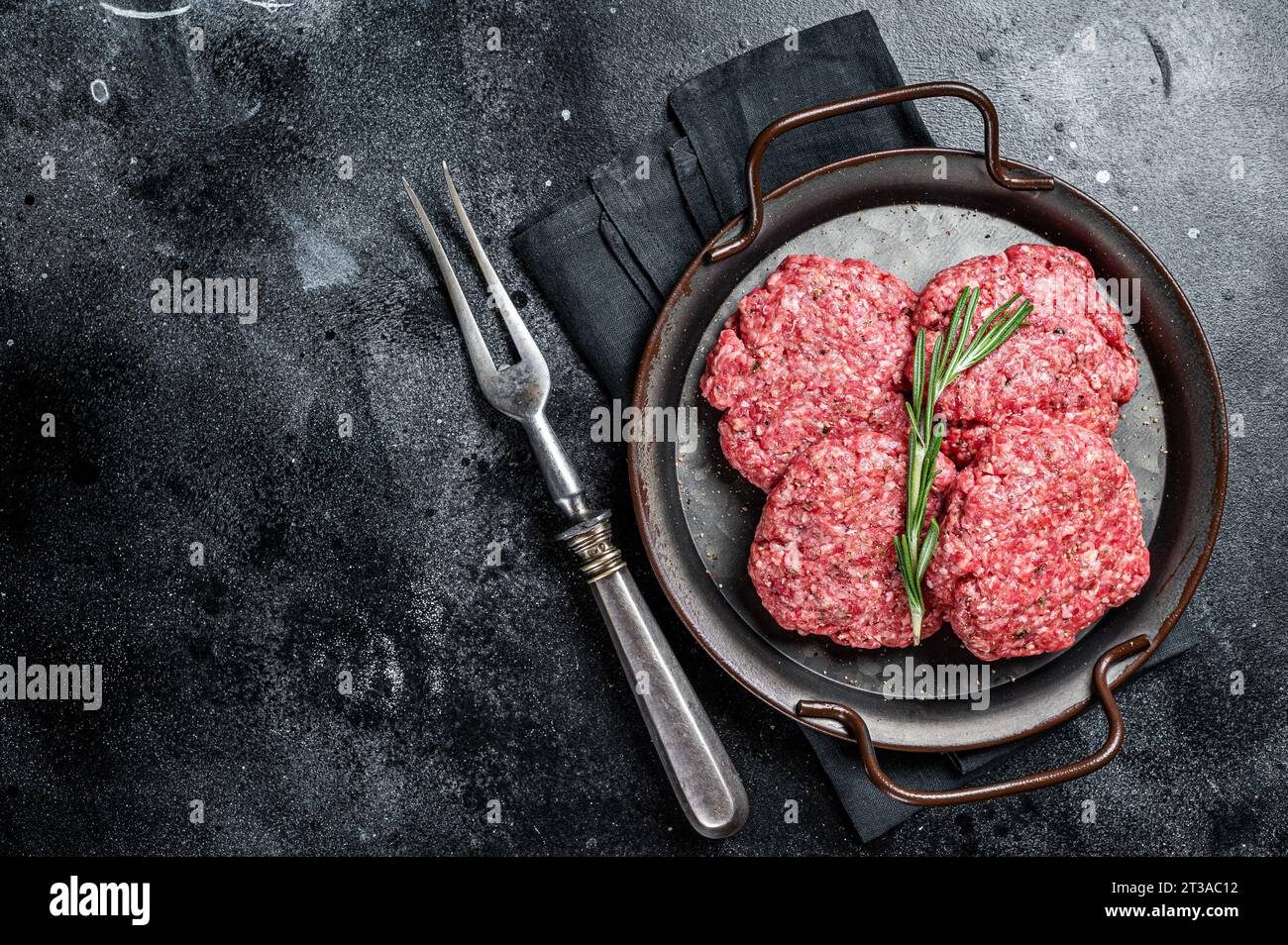 Rohe Frikadellen aus Hackfleisch, rohe Fleischkoteletts. Schwarzer Hintergrund. Draufsicht. Leerzeichen für Text Stockfoto