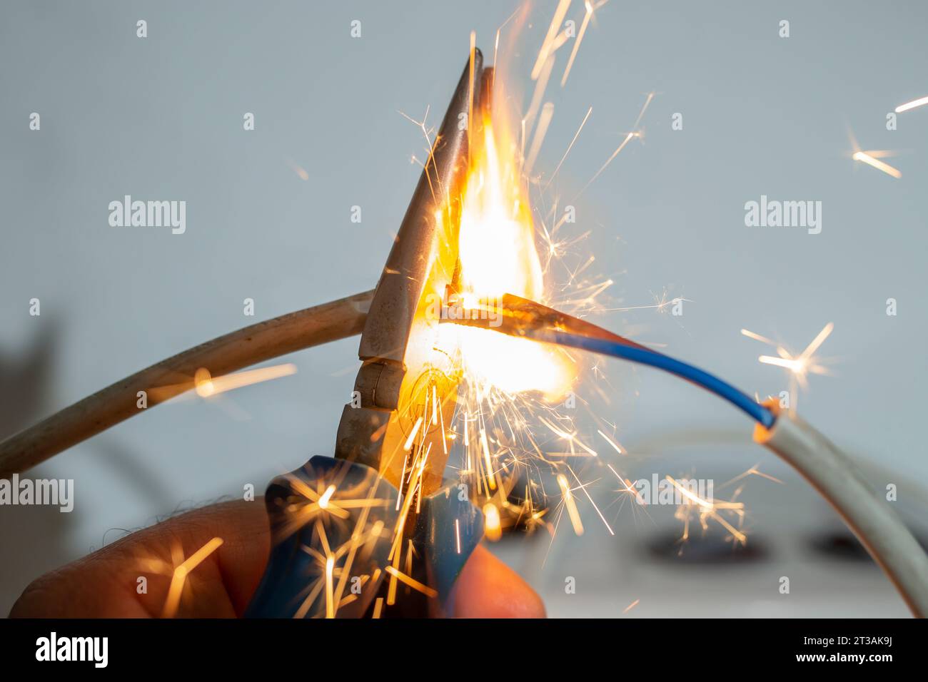 Flammen und Funken mit einer Zange, die elektrische Kabel schneidet, Brandschutzkonzept, Soft Focus Stockfoto