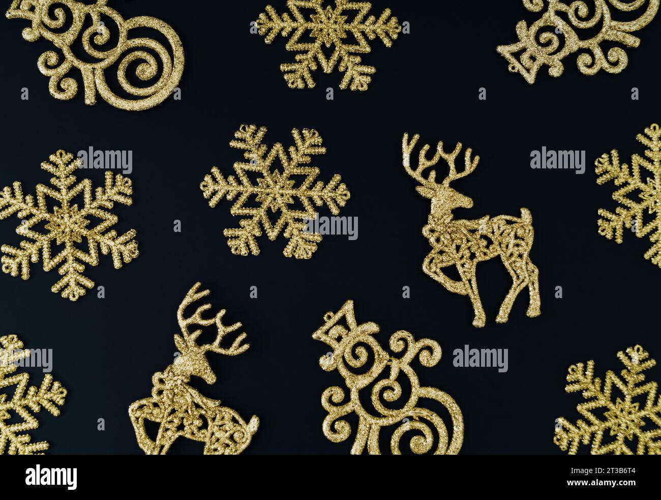 Trendige Komposition mit weihnachtlichen Hintergrundmustern aus verschiedenen goldenen Weihnachtsdekorationsobjekten. Minimales Weihnachts- oder Neujahrskonzept. Schicker Winter Stockfoto