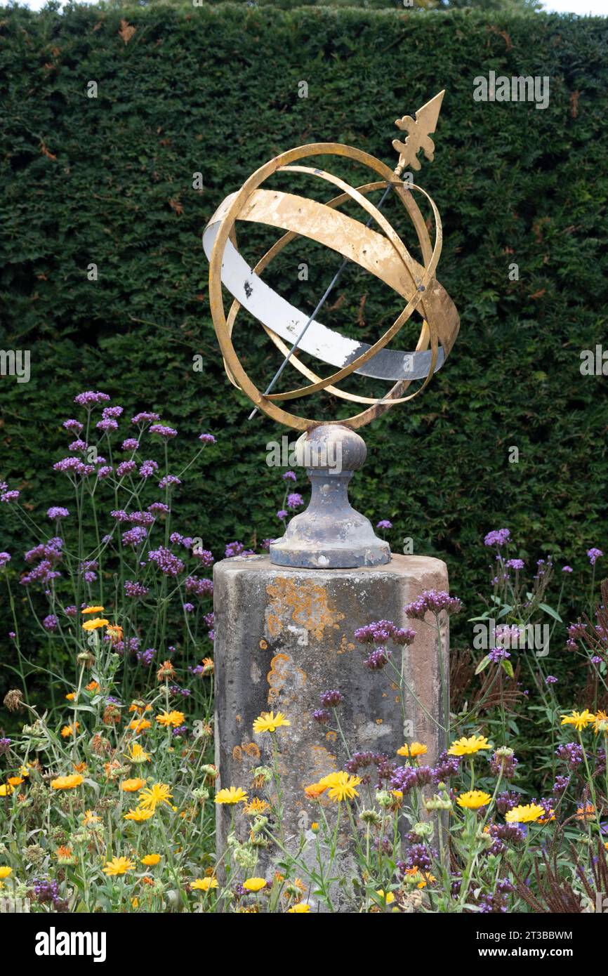 Armillary Sphere Sonnenuhr in einem Garten umgeben von Wildblumen Stockfoto