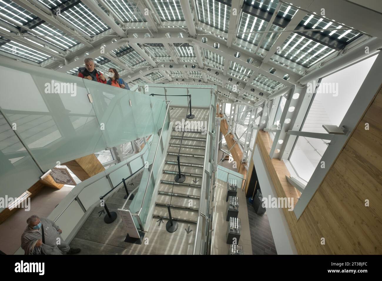 Hochwinkelblick auf das Innere des Bahnhofs Pointe Helbronner auf dem Skyway Monte Bianco mit ein paar Rucksacktouristen Courmayeur, Italien Stockfoto