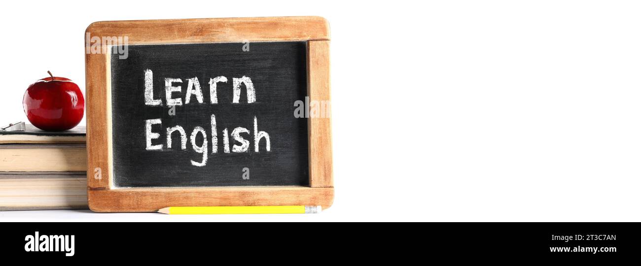 Bücher, Apfel und Tafel mit Text LERNEN SIE ENGLISCH auf weißem Hintergrund mit Platz für Text Stockfoto